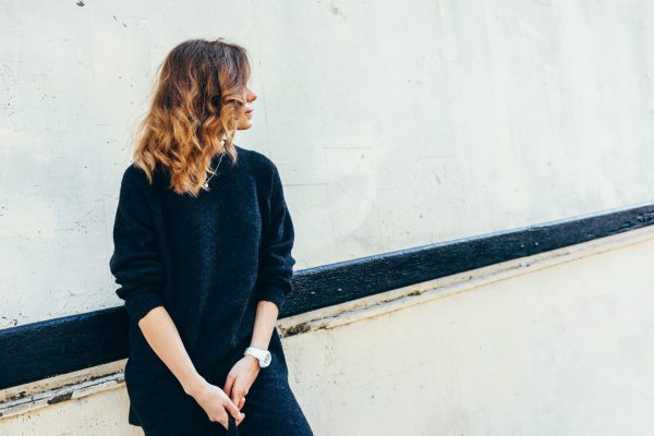 Woman with curly hair on a background of a wall in the city